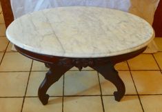 a marble topped table sitting on top of a tiled floor