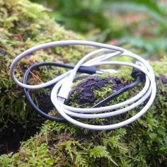 a close up of a metal object on a mossy surface