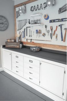 there is a large workbench with many tools on the wall and hanging utensils