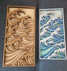 two wooden boxes with designs on them sitting next to each other