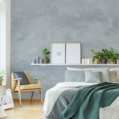 a bedroom with a bed, chair and potted plants on the shelf above it