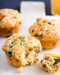 several small muffins with cheese and spinach in them on a white surface