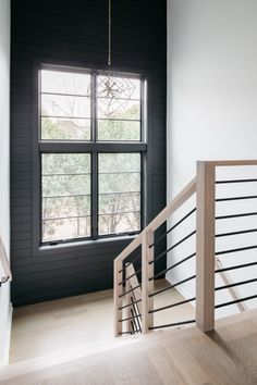 an empty room with black walls and wooden stairs