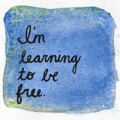 the words i'm learning to be free written on a blue watercolor background