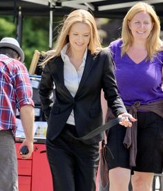 two women in business attire walking down the street