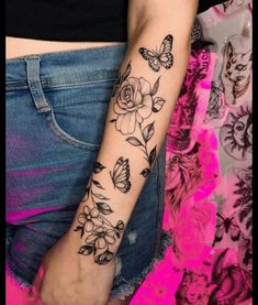 a woman's arm with flowers and butterflies on it