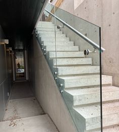 a set of white stairs leading up to a room with concrete walls and flooring