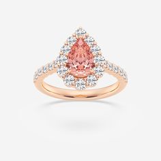 a pink diamond ring with white diamonds on the shoulders and an oval shaped center surrounded by small