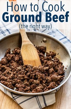 a wooden spoon in a metal pan filled with ground beef and spices on a table