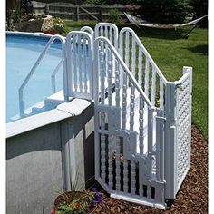 an above ground swimming pool with a white fence and steps leading up to the pool