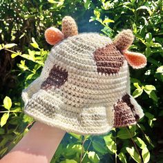 a crocheted hat with two brown and white giraffes on it