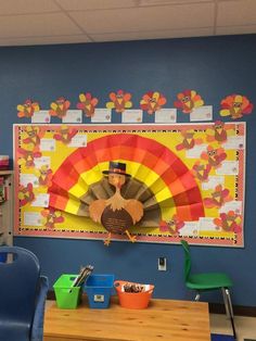 a classroom with blue chairs and a bulletin board on the wall that has a colorful fan