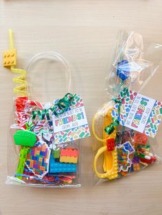 two plastic bags filled with legos on top of a wooden table next to each other