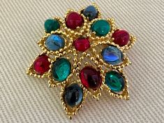 "Colorful MOGHUL Cabochon Vintage Ruby Emerald Sapphire Glass Brooch Pin c. 1970s  -Fabulous ruby, emerald, and sapphire glass cabochons in a gold tone setting  -Excellent vintage condition with age appropriate wear  -Signed with a production number but no designer  -Size: 1 3/4\" long x 1 1/2\" wide" Multicolor Cabochon Brooch For Gift, Multicolor Cabochon Brooch As Gift, Multicolor Cabochon Brooches For Gifts, Multicolor Cabochon Brooches As Gift, Multicolor Cabochon Brooches For Collectors, Black Tissue Paper, Cardboard Jewelry Boxes, Ruby Emerald, Brooch Pin