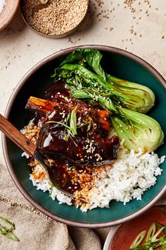 a bowl filled with rice and vegetables on top of a table