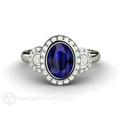 an oval shaped blue sapphire and diamond ring in white gold with diamonds around the band