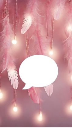 pink feathers with white speech bubble hanging from the ceiling and lights in the back ground