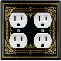 an ornate black and gold outlet cover with two white outlets in the center, on a black background