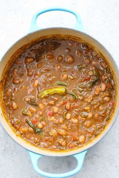 a blue pot filled with beans and vegetables