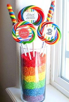 there are many lollipops in the glass on the window sill with candy