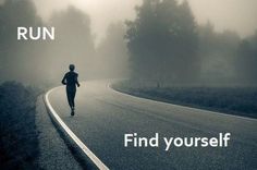 a person running down a road in the foggy day with trees on both sides