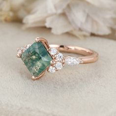 a close up view of a ring with an emerald stone and two diamonds on it