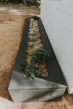 a concrete planter sitting next to a white building