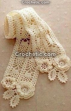 crocheted lace with flowers and leaves is shown on a beige background, it looks like an old scarf