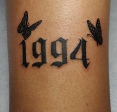 a tattoo with butterflies on the side of it that reads,'949 '