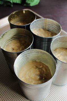 six tins filled with food sitting on top of a table