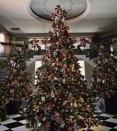 the christmas tree is decorated with red, white and blue ribbon bows on it's branches