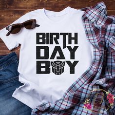 a shirt that says birth day boy on it next to some sunglasses and plaid shirts