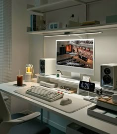 a desk with a computer monitor, keyboard and speakers