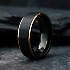 a black and gold wedding band with an inlay design on the inside of it