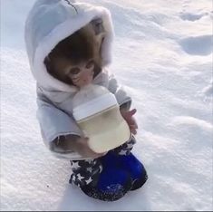 a small child holding a cup in the snow