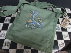 Embroidered 100% cotton canvas messenger bag with whale and mushroom design the bag colour is olive green the bag measures height 29cm's, width 26cm's, depth 10cm's it has an adjustable strap, two generous front pockets and a zip front pocket, the main part has a zip closure and a zip pocket to the back. the embroidered design colours can be customised please message me with your requirements. Green Cotton Satchel Bag, Green Cotton Satchel For Daily Use, Green Cotton Satchel Shoulder Bag, Daily Use Green Cotton Satchel, Functional Green Canvas Bag With Pockets, Green Canvas Crossbody Satchel, Green Cotton Bags With Embroidery, Green Embroidered School Bag, Green Embroidered Cotton Bags