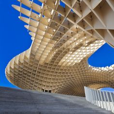 an architectural structure with curved white lines on the side and stairs leading up to it