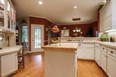 a large kitchen with white cabinets and wood flooring is seen in this image from the inside