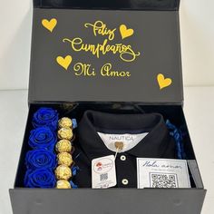 a black box with blue roses and chocolates in it