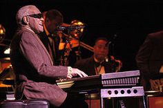 a man sitting at a keyboard in front of music instruments