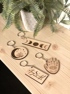 the wooden keychains are next to a potted plant and some keys on a table