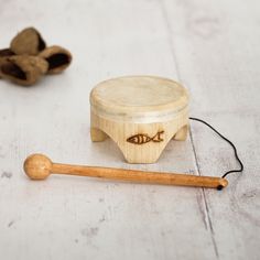 a wooden toy with a fish on it next to an object that looks like a mallet