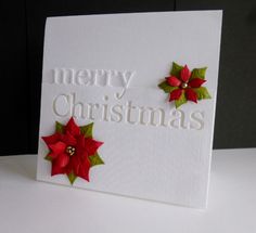 a white card with red poinsettis and merry christmas written on the front