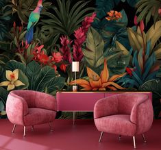 two pink chairs and a table in front of a wall with tropical plants on it