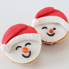 two cupcakes with frosting decorated like snowmen