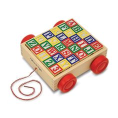 a wooden toy with red wheels and letters on the front, sitting next to a rope