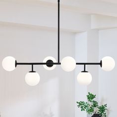 This 6-Light sputnik modern Linear chandelier pendant light is a great blend of modern classic and transitional styles. It's shaped in modern linear and glass globes , featuring matte black finish and white frosted opal glass shades, , which looks low-profile but has the elegant and minimalist aesthetics. The glass sphere hanging light is an eye-catching and focal piece to help complete a timeless interior decor, is ideal for over kitchen island and dining room table, or in a living room and hot Dining Table Black Light Fixture, Kitchen Table Lighting Fixtures Modern, Pendant Lights Over Dining Table, Chandelier Over Island, Modern Chandelier Foyer, Modern Black Chandeliers, Lights Over Dining Table, Modern Linear Chandelier, Signal Hill