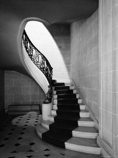 a black and white photo of a staircase in a building with tile flooring on both sides