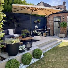 an outdoor living area with potted plants and patio furniture