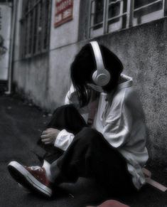 a person sitting on the ground wearing headphones